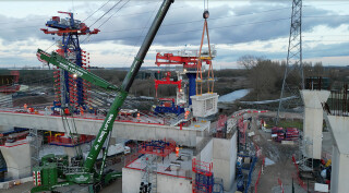 The balanced cantilever method uses a 22m steel mast (on the left) and a 14m tall swivel crane to handle the concrete segments